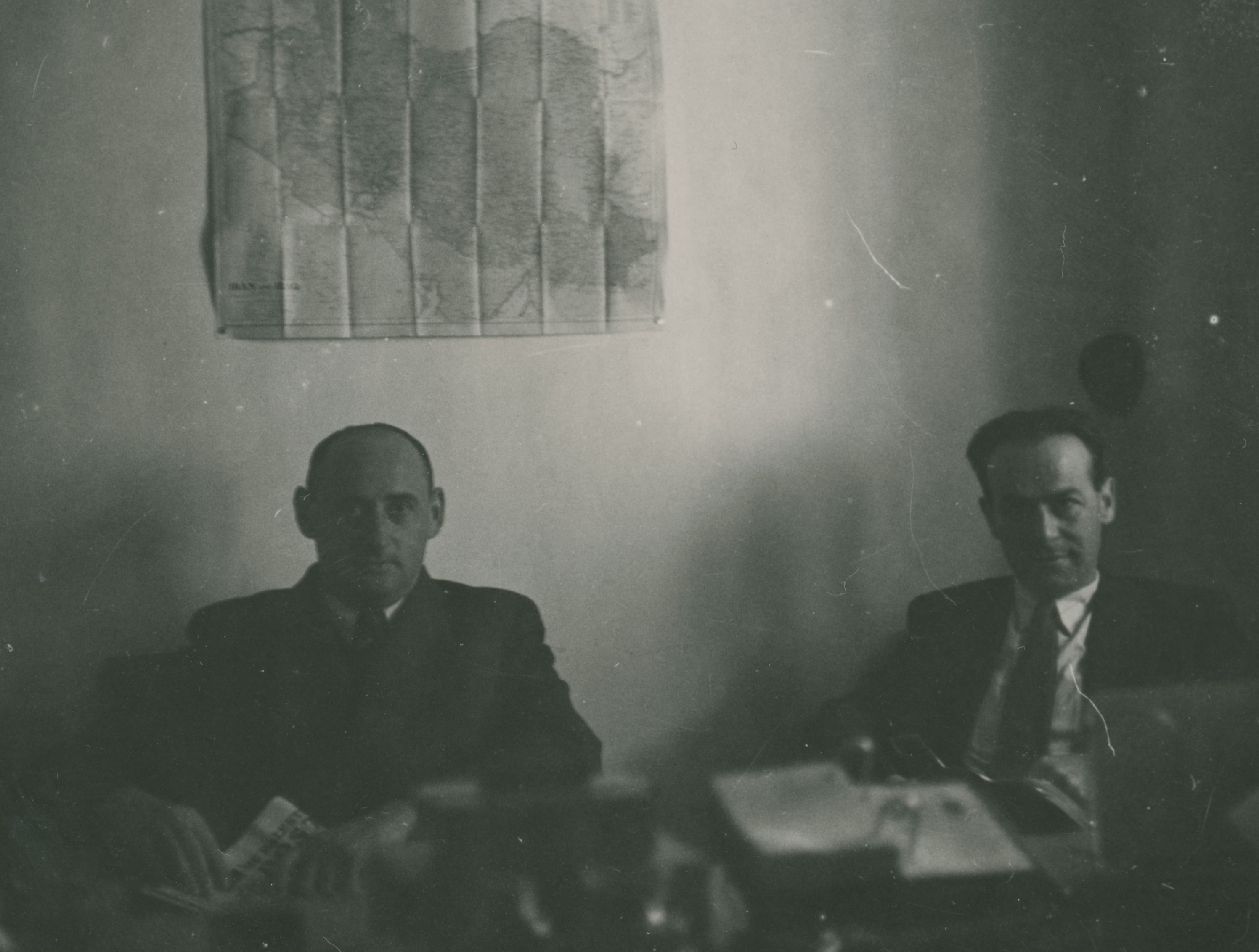 ערן לאור (משמאל) במשרדי הסוכנות היהודית בטהרן על רקע מפת אירן, 1945