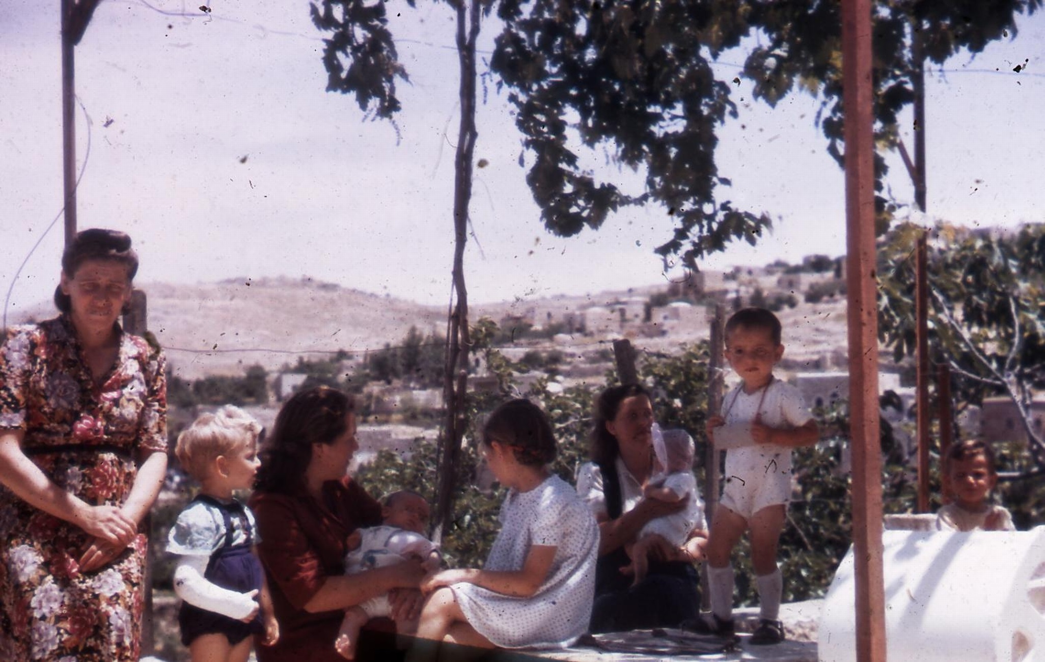 עולים חדשים על רקע בתי עין כרם הנטושה, 1950 בקירוב