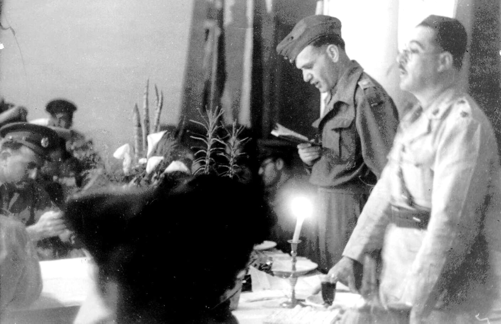 קצין יהודי קורא בהגדה בחגיגות ליל הסדר בקרבת טריפולי, 1943