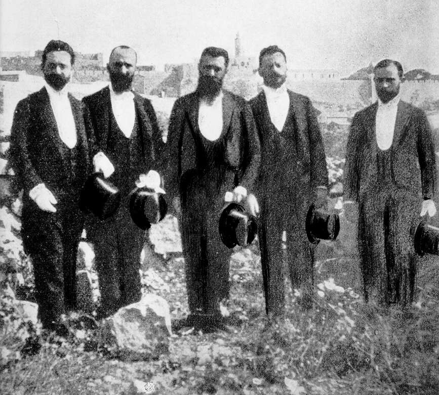 חברי המשלחת על רקע חומות העיר העתיקה לאחר המפגש עם הקיסר הגרמני, 1898