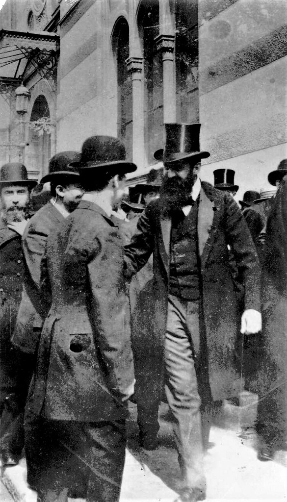 הרצל משוחח עם אנשים בצאתו מבית הכנסת בבאזל, על פניו חיוך, 1903 (PHG\1002043)