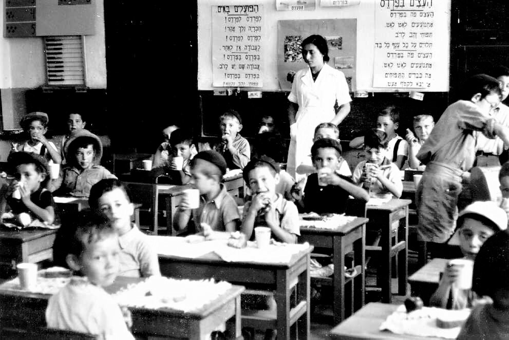 אחות מפקחת על שתיית החלב בכיתה, 1945 בקירוב (PHG\1015300)