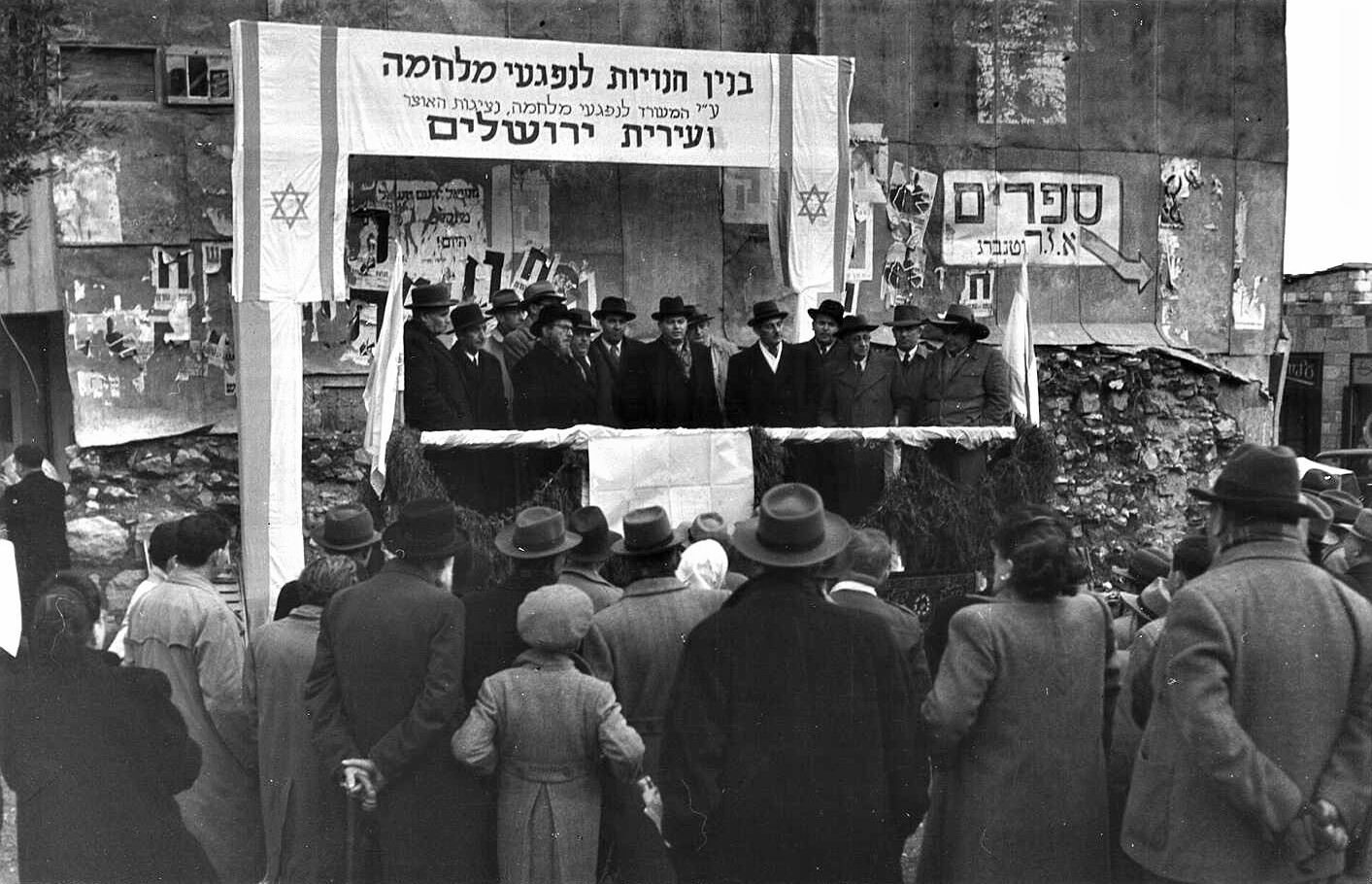 טקס הנחת אבן פינה לבניין חנויות לנפגעי מלחמה, רחוב בן יהודה, 1949 (PHSC\1201607)