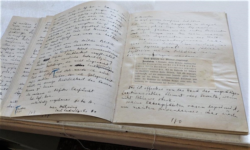 דיווח מהעתון על ביקורו של הקיסר הגרמני, שהודבק על ידי הרצל. הדבק יצר גלים והקשיח את הנייר. (H1\77)