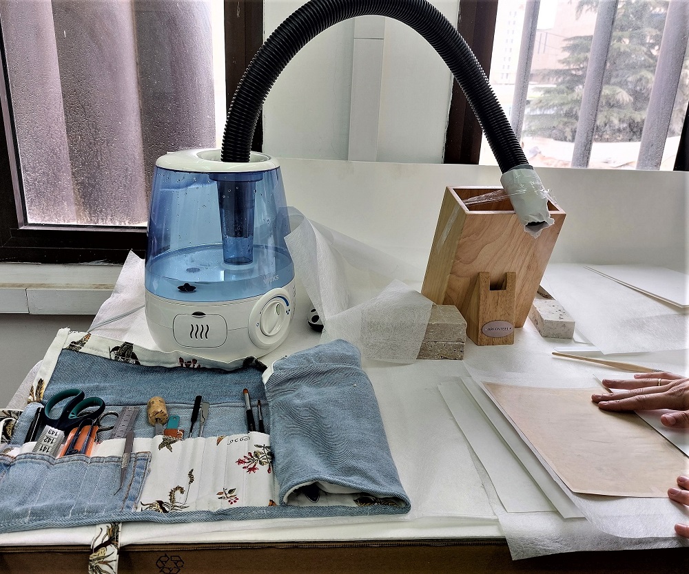 שימוש במכשיר אדים כדי לרכך את הדבק מבלי לפגוע בדיו