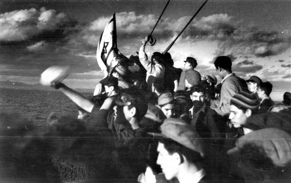 עולים על סיפון האונייה "אנדריאה" מניפים את הדגל הציוני בדרכם ממחנות המעצר בקפריסין לארץ ישראל, 1947. (PHAL\1604480)
