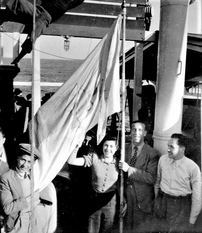 הדגל הציוני בידי פליטים מאירופה על סיפון האונייה "ניסאה", 1944. (PHG\1006117)