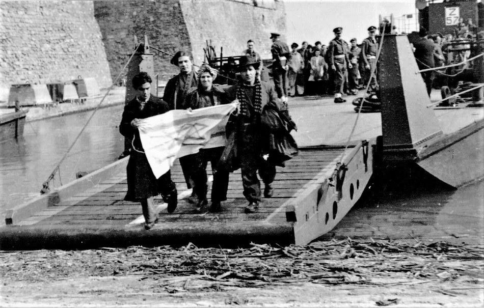 מעפילים מקפריסין עם הגעתם לארץ ישראל ובידיהם הדגל הציוני, 1947. (PHG\1010575)
