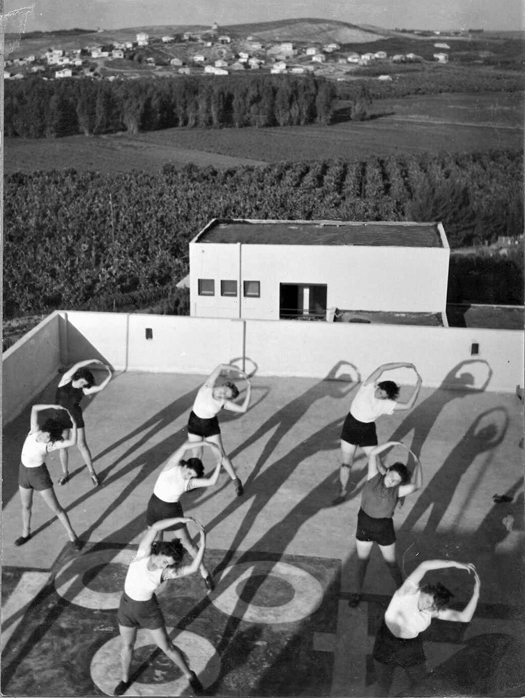 חניכות משק הפועלות ב"עיינות" מתעמלות על גג הבניין, צלם: מ. שוורץ (PHWI\1245174)