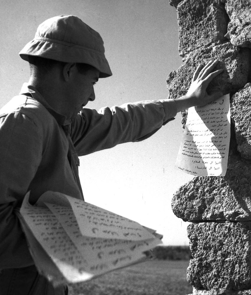 איש "ההגנה" תולה כרוזים הקוראים לערבים לא לסייע לכנופיות